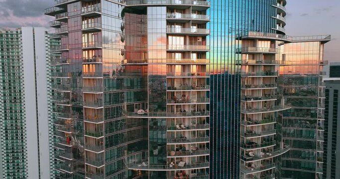Glass facades of a skyscraper building with a reflection of a sunset landscape. Downtown Miami Florida. Aerial view. Abstract modern business architecture.