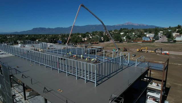 Aerial view of a concrete pour on a commercial building with mountains