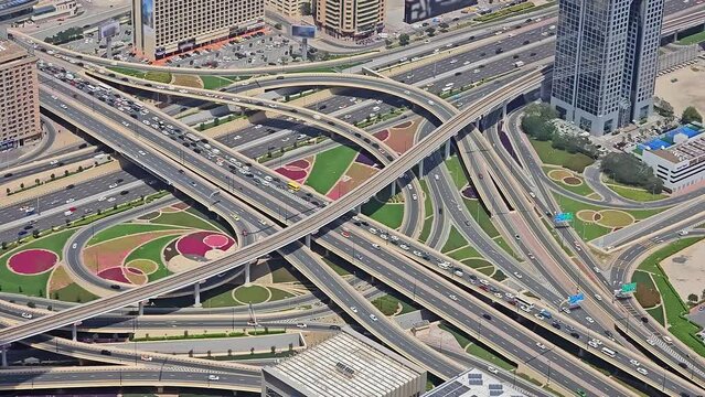 Aerial View of Complex Highway Interchange in Dubai, Top-down view of a colorful and complex highway interchange with lush landscaping and multiple roadways in Dubai