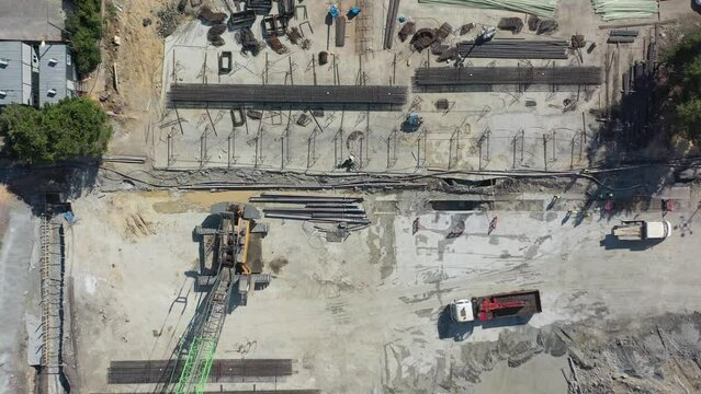 aerial view of top-down diaphragm wall reinforcement and giant crawler crane at construction site