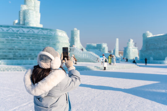 年轻快乐的女游客在中国哈尔滨冰雪世界节尽情享受