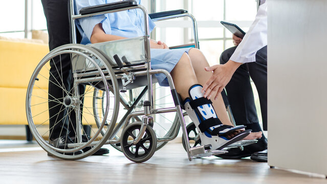 特写：亚洲医生在医疗诊所为老年女性患者检查腿部夹板支撑，护理员协助，骨科创伤治疗团队提供康复理疗服务