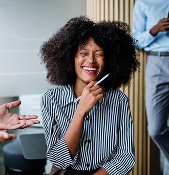 一群年轻的商务人士在办公室里站着进行会议、展示或研讨会。一位年轻女商人正在讲话的特写。