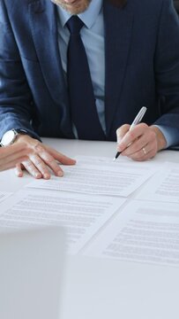 商人在办公室的白色办公桌前签署合同文件，同事们为谈判的成功结果鼓掌。商业人士概念