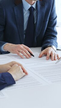 商务人士同事在办公室会议上审阅合同文件，讨论条款并为签署协议做准备，重点进行法律咨询和合作讨论