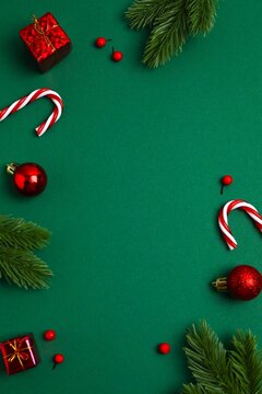 A festive Christmas flat lay with decorations on a dark green background. View from above, vertical composition