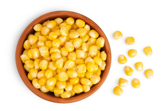 白色背景上单独放置在陶瓷碗中的玉米粒。顶视图。平铺