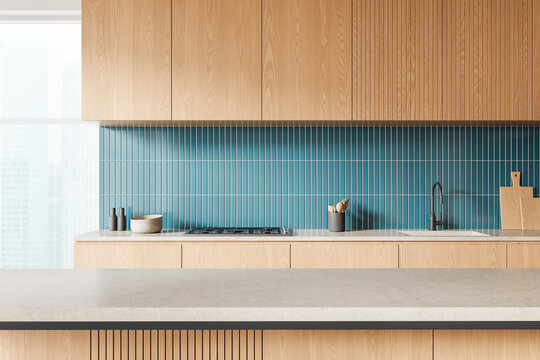 现代厨房室内设计，亮木橱柜搭配蓝色竖纹瓷砖背板，明亮背景。3D渲染图