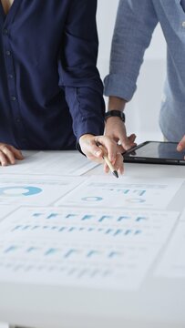 专业团队审核财务文件，指着桌上图表，共同分析数据并制定业务增长策略。商业人士概念