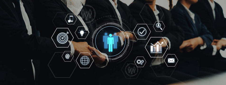 A group of business professionals in suits participates in a corporate meeting, surrounded by digital icons symbolizing networking and teamwork concepts. Trope