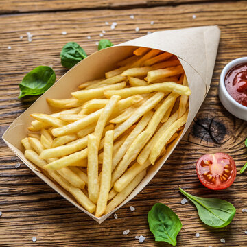 纸托装配有番茄酱和罗勒叶的薯条