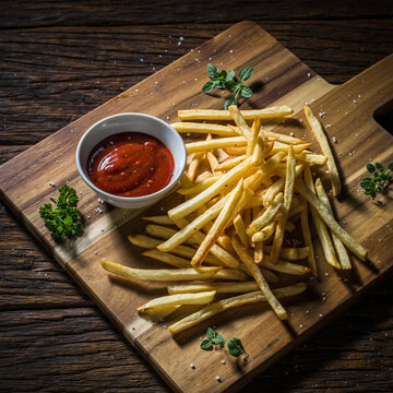 木质切菜板上搭配番茄酱的法式薯条
