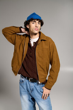 一位年轻时尚的男子在充满创意的工作室环境中，带着酷炫自信展示现代时尚风采。