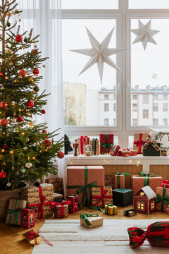 布置有圣诞装饰、闪烁星星灯和节日抱枕的温馨客厅。有礼物和柔和灯光营造出温暖的节日氛围。