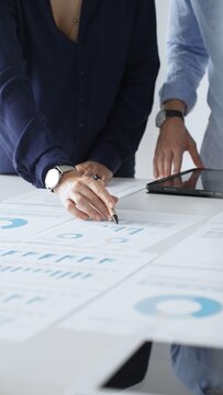 专业团队审核财务文件，指着桌上图表，共同分析数据并制定业务增长策略。商业人士概念