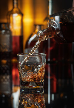 将威士忌从瓶子倒入玻璃杯中。