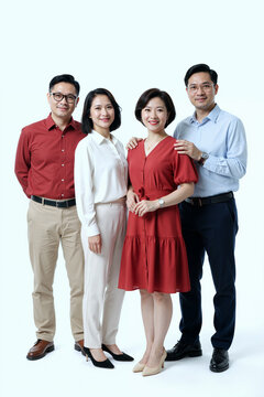 四名亚洲中年成年人站在一起对着镜头微笑，两名男性和两名女性带着友好的表情在纯色背景前紧紧摆姿势