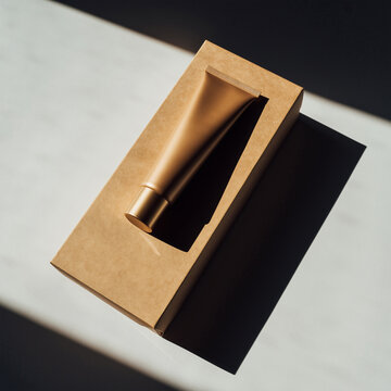 阳光照耀下置于敞开硬纸盒中的金色化妆品管模型