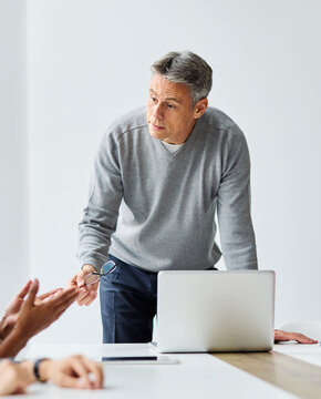 一群商务人士在办公室开会的画像。团队合作与成功理念，一位睿智中年商人的画像