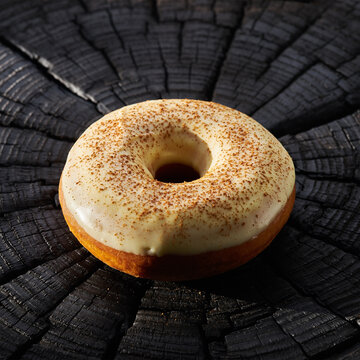 黑色质感表面带阴影的鲜绿色糖霜甜甜圈