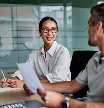 年轻女商人和中年商人在办公室进行会议、展示或研讨会的画像