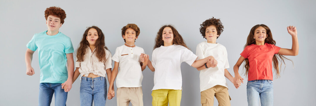 充满活力、趣味十足的团体儿童画像：年轻快乐的多元学校学生、青少年们紧密相聚，跳跃欢笑，展现教育社区、创意青少年俱乐部聚会的欢乐、精神与团队建设氛围