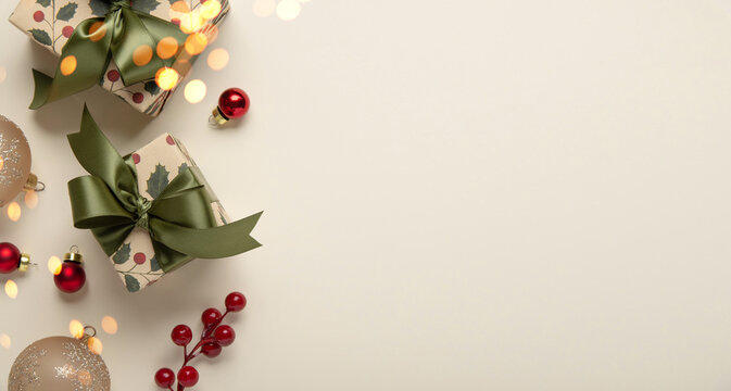 Merry Christmas and Happy Holidays greeting card, frame, banner. New Year. Christmas ornaments and gifts, presents on light beige background top view. Winter xmas holiday festive theme.