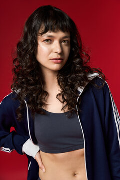 优雅的年轻女性身着时尚服饰，在充满活力的背景前散发自信