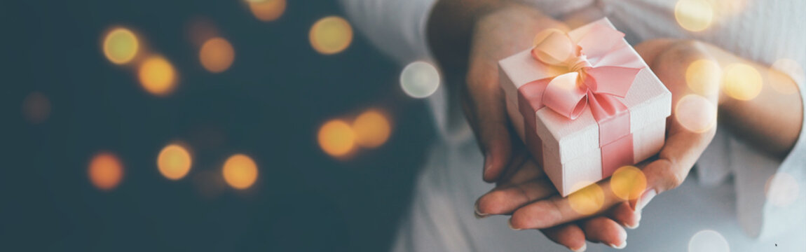 女性手持饰有圣诞与新年横幅的圣诞礼盒 2025、2026年圣诞新年快乐概念