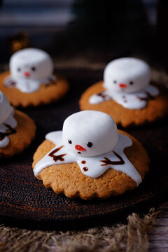 Gingerbread cookie with melting snowman topping on a wood background