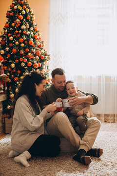 Happy family enjoying christmas together with hot drinks