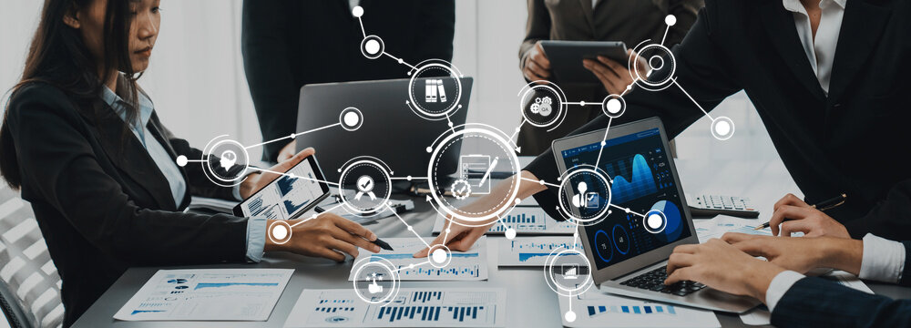 全景镜头下分析师团队利用BI金融科技通过笔记本电脑分析财务报告；商务人士分析笔记本屏幕上的BI数据仪表盘以获取商业洞察（普洛迪吉·阿米蒂）