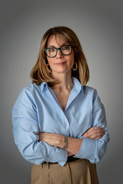 金发自信女性的特写，她站在纯色背景前